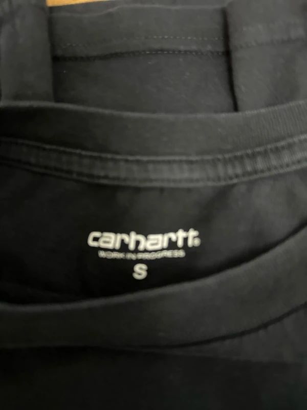 black Carhartt WIP t-shirt with a camouflage-patterned script logo across the chest. Small