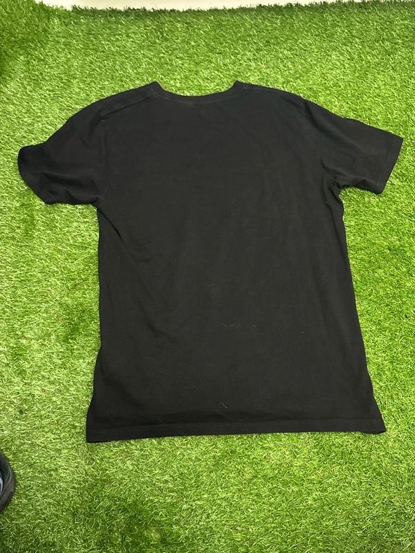 black Carhartt WIP t-shirt with a camouflage-patterned script logo across the chest. Small